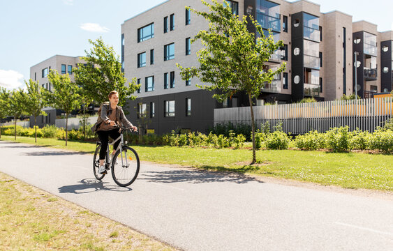 Lifestyle, Transport And People Concept - Young Man Or Teenage Student Boy With Backpack Riding Bicycle On City Street