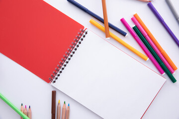 collection of colorful felt-tip pens with notebook on light background, close view. High quality photo