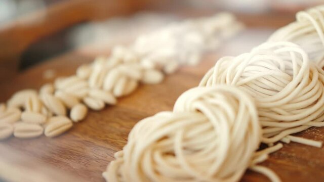 Home made pasta on the table with flour. Fresh pasta with wheat flour. Penne rigate Fresca pasta. Traditional italian food, high haute kitchen restaurant.