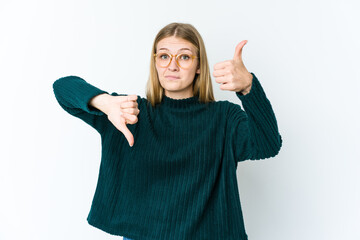 Young blonde woman isolated on white background showing thumbs up and thumbs down, difficult choose concept