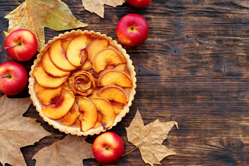 Apple tart pie and red apples on wooden table