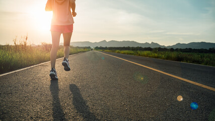 athlete woman runner running on a Countryside Road at Sunrise.Jogging workout and sport healthy lifestyle.Active,start up and healthy lifestyle concept.