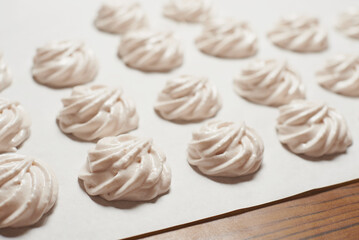 Cooked homemade meringue cookies on baking paper, homemade sweet food
