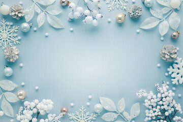 Christmas frame  with festive decorations, snowflakes, baubles on pastel background. Flat lay. Top...