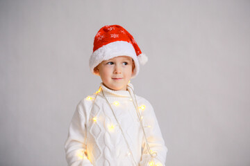 Happy child in Santa red hat. White isolated background. Christmas. Garland