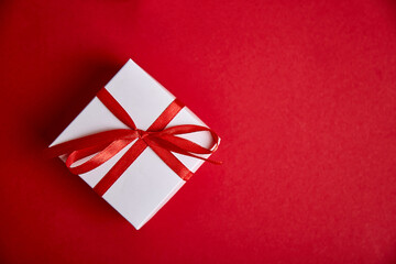 Luxury white gift boxes with red ribbon on red background.