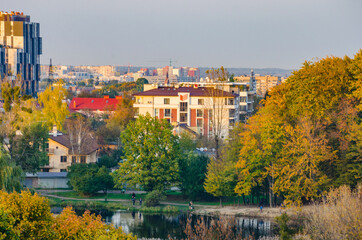 Obraz premium Landscape with autumn park in the sunny day. Yellow and green trees are displayed with reflection on the lake.