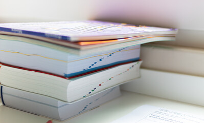 stack of books on a table waiting to be opened for study.