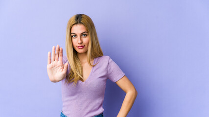 Fototapeta na wymiar Young blonde caucasian woman standing with outstretched hand showing stop sign, preventing you.