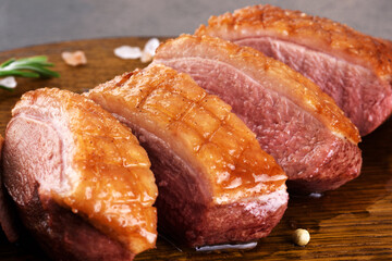 Roasted duck breast sliced on a cutting board.