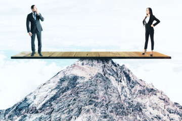 Two businesspeople standing on wooden board on mountain top.