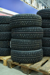 New winter car tires lie on the pallet in a store
