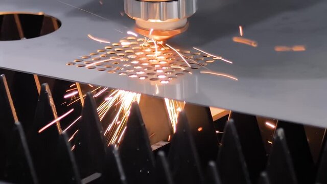 Slow motion: automatic cnc laser cutting machine working with sheet metal with sparks at factory, plant. Metalworking, machining, industrial, equipment, technology, manufacturing concept