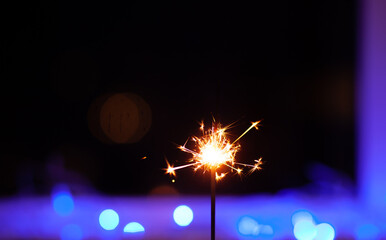 Sparks and fire on a black and blue background. Festive Merry Christmas sparklers. Golden Magic...