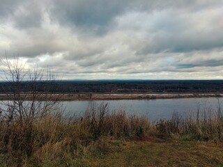 river on the background of the evening cloudy sky in the autumn landscape
