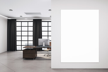 Modern office room with blank vertical poster on wall.