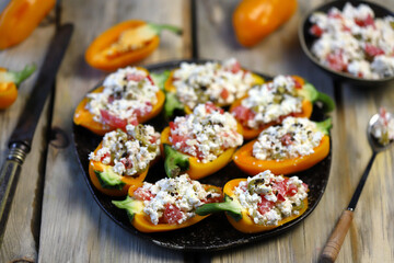 Selective focus. Macro. Yellow paprika peppers stuffed with ricotta cheese with vegetables. Keto...