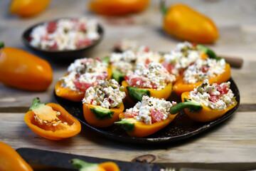 Selective focus. Macro. Yellow paprika peppers stuffed with ricotta cheese with vegetables. Keto...
