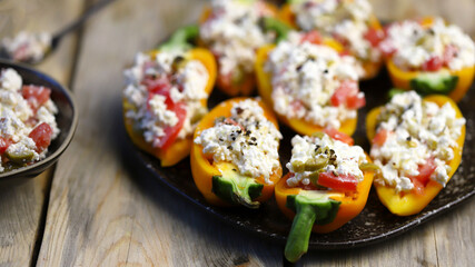 Selective focus. Macro. Yellow paprika peppers stuffed with ricotta cheese with vegetables. Keto snack. The keto diet.