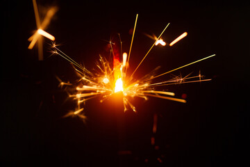 Sparks and fire on a black and blue background. Festive Merry Christmas sparklers. Golden Magic...