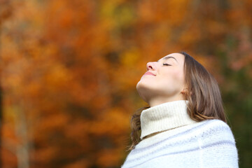 Relaxed woman breathing fresh air in autumn in a park