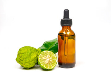 Bergamot oil in bottle and fresh bergamot fruit with green leaf isolated on white background.