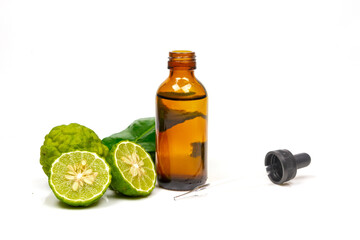 Bergamot oil in bottle and fresh bergamot fruit with green leaf isolated on white background.