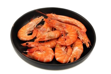 Crevettes dans une assiette noire en gros plan sur fond blanc