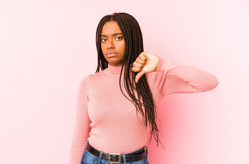 Young african american woman isolated on a pink background showing a dislike gesture, thumbs down. Disagreement concept.