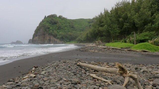 4k left to right panning View of Pololu Valley black sand Beach in wet weather with the cliffs in the background,Big Island, Hawaii, USA