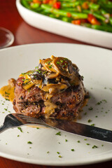 Steak dinner w/ vegetables. Traditional classical American or French Bistro main course, steak and mashed potatoes. Steak, cooked medium rare served with garlic mashed potatoes and kale salad.  