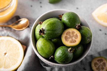 ripe feijoa with lemon and honey on a white table