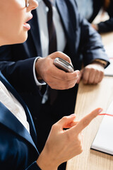 cropped view of correspondent with dictaphone interviewing politician pointing with finger during...