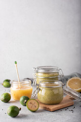 feijoa mashed with lemon and honey in glass jars on a light background