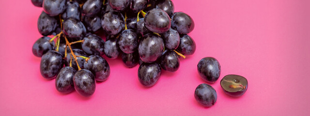 Top view bunch of ripe fresh black grape berry on pink surface