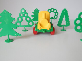 toy train among plastic trees

