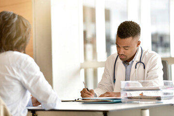 Young doctor in office having an appointment with woman patient