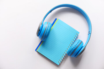 Audio book concept. Headphones and notepad on white background 