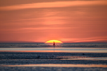 Menschen im Watt von Cuxhaven im Sonnenuntergang