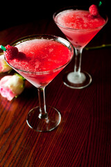 Cosmopolitan Cocktail. Action shot. Alcoholic Drinks made with gin, vodka, rum or whiskey mixed with soda water, fruit juices and garnishes with limes and cherries. Classic American bar drinks.