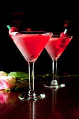 Cosmopolitan Cocktail. Action shot. Alcoholic Drinks made with gin, vodka, rum or whiskey mixed with soda water, fruit juices and garnishes with limes and cherries. Classic American bar drinks.