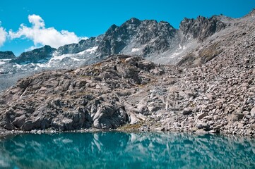 A lake in the Italian Alps with snowy mountains in background (Trentino, Italy, Europe)