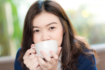 Business asian women sitting in cafe drinkking coffee