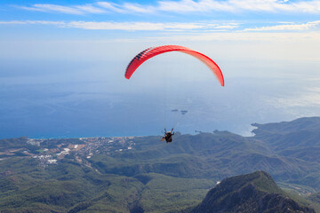 Paragliders flying from a top of Tahtali mountain near Kemer, Antalya Province in Turkey. Concept of active lifestyle and extreme sport adventure