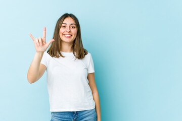 Young caucasian woman showing a horns gesture as a revolution concept.