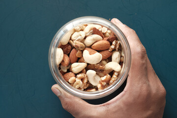  a bowl of mixed nut on green background top down 