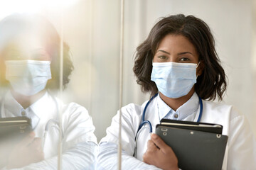 Woman doctor standing in hospital, wearing face mask