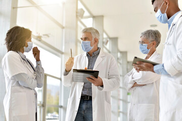 Obraz premium Group of doctors meeting in hospital for instructions and medical report during 19-ncov pandemic