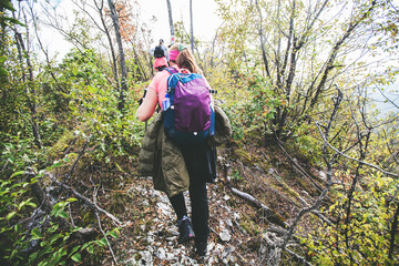 Hiking Woman with backpack. Walking on forest trail on autumn day. Nature lifestyle.