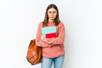 Young student woman isolated on white bakcground frowning face in displeasure, keeps arms folded.